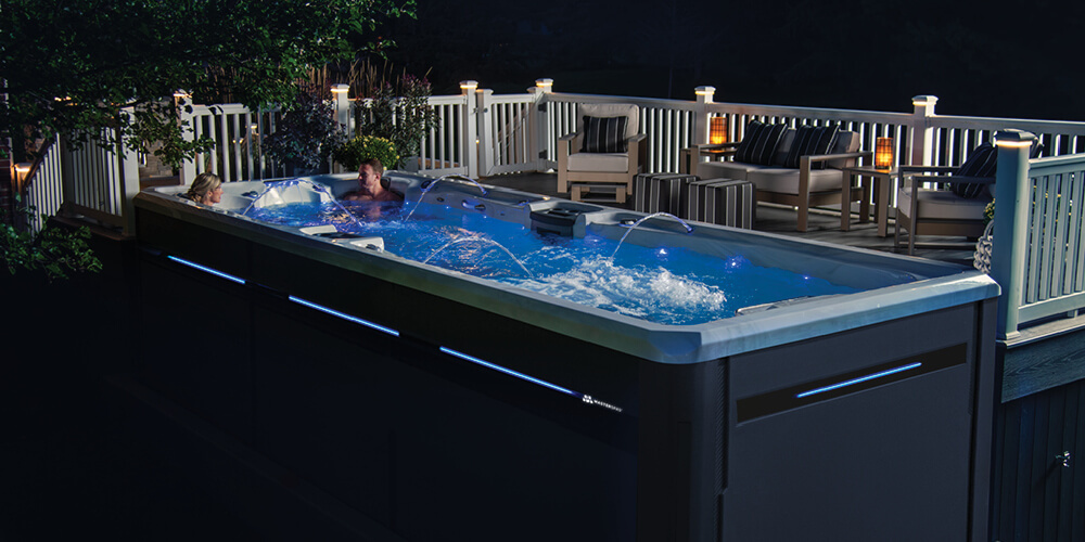 Swim spa at night with all the LEDs turned on and water features running.